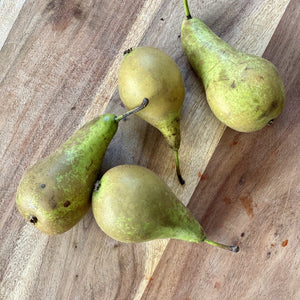 4 conference pears on a wooden board