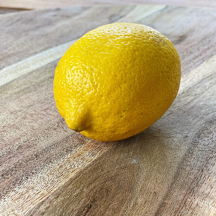 fresh yellow lemon on a wooden board