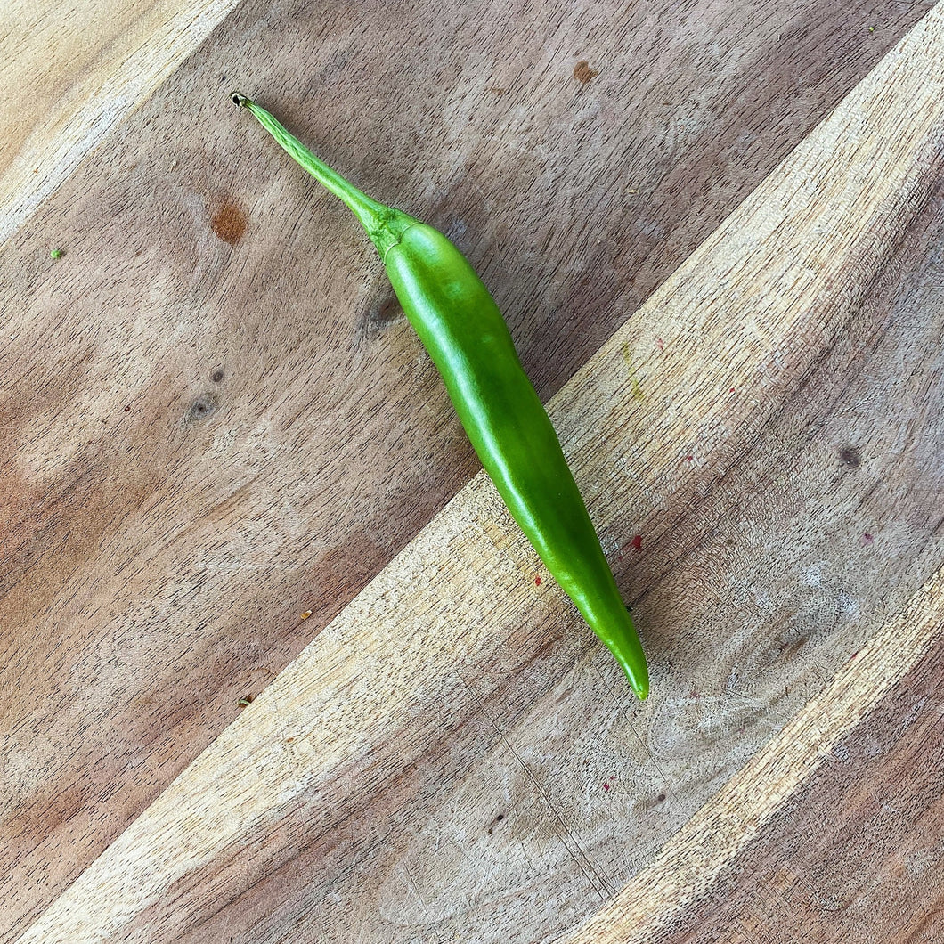 fresh green chilli on a wooden board