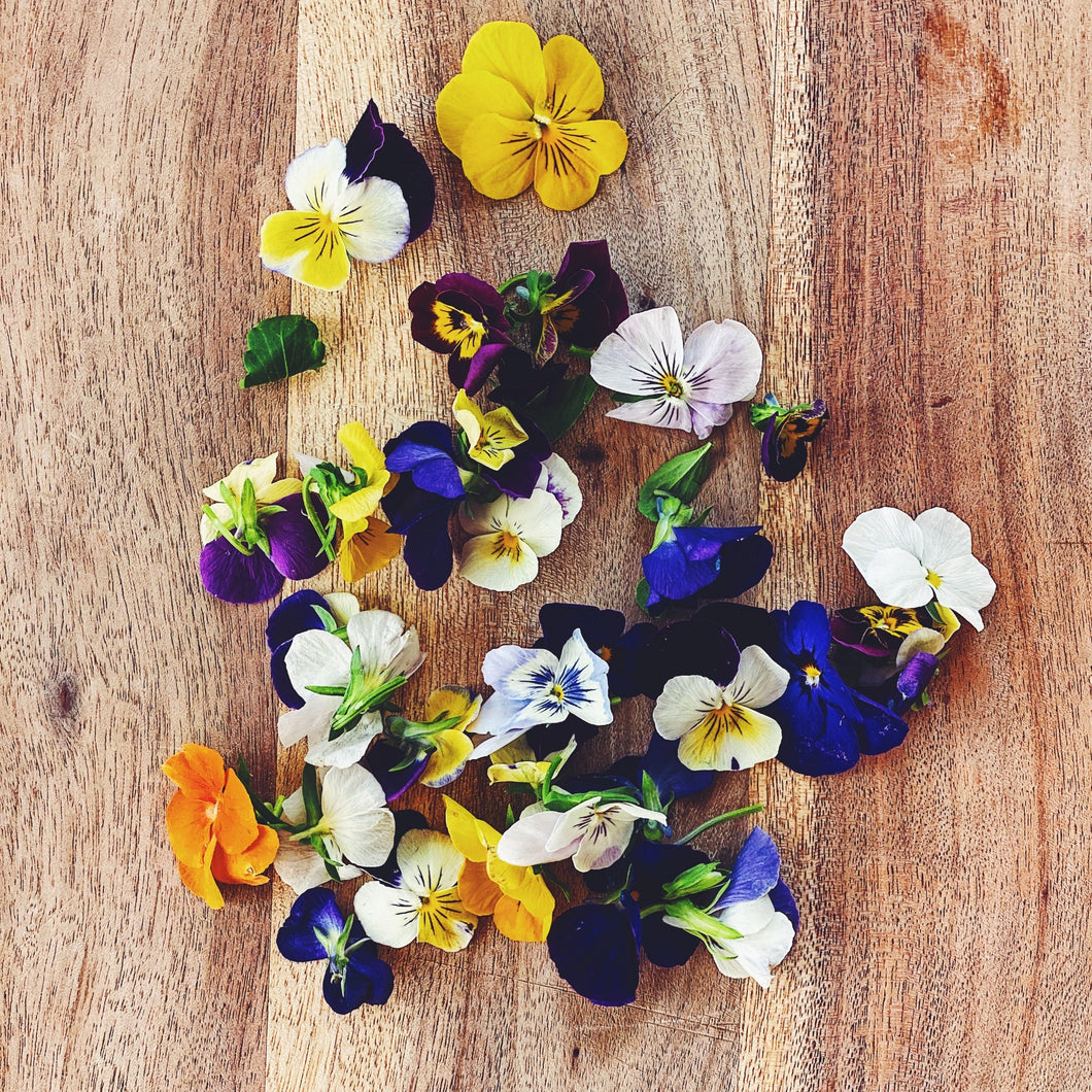 edible viola flowers on a wooden board