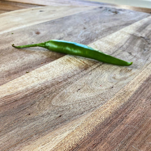 fresh green chilli on a wooden board
