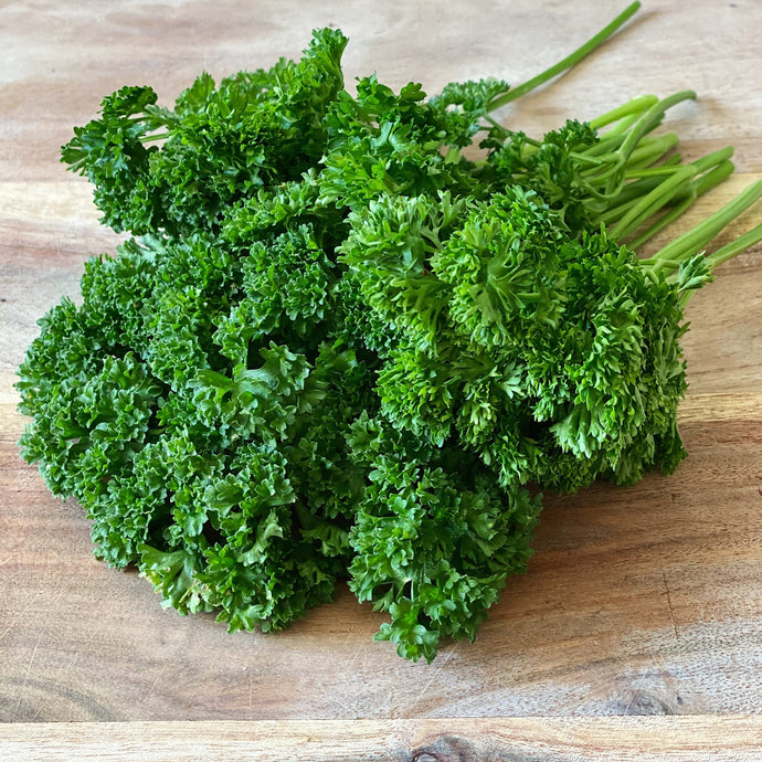 bunch of fresh parsley on a wooden board