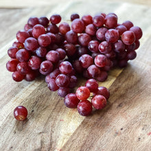 Load image into Gallery viewer, bunch of purple red grapes on a wooden board
