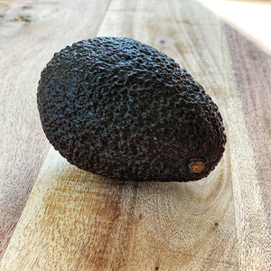 ripe hass avocado on a wooden board