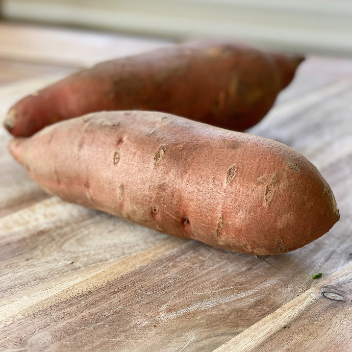 2 sweet potatoes on a wooden board