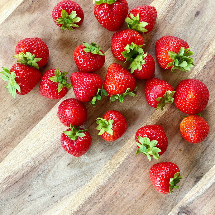 collection of fresh british strawberries on a wooden board