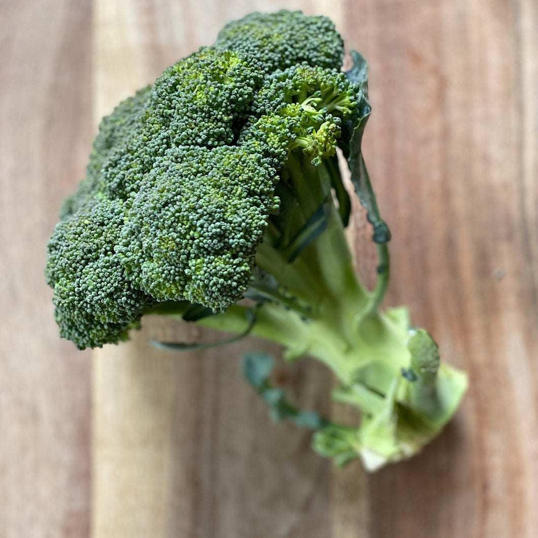 crown of brocolli on a wooden board