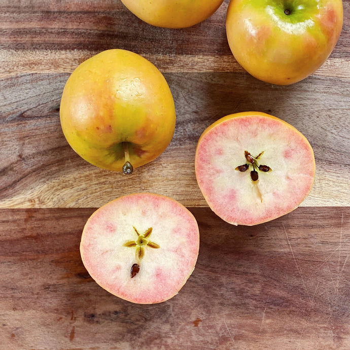 Kissabel apples on a wooden board, one cut open
