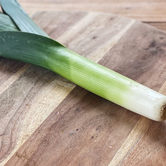 single leek on a wooden board