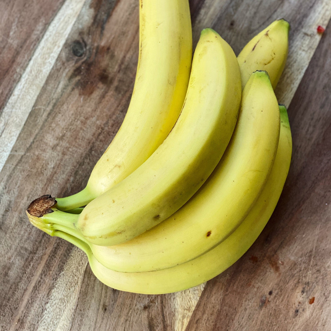 bunch of 5 bananas on a wooden board