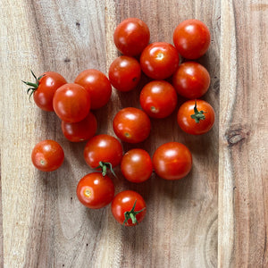 fresh cherry tomatoes on a wooden board