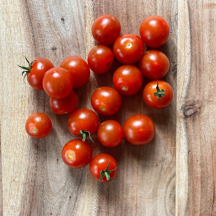 fresh cherry tomatoes on a wooden board