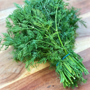 fresh bunch of dill on a wooden board