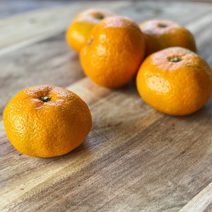 5 satsumas on a wooden board