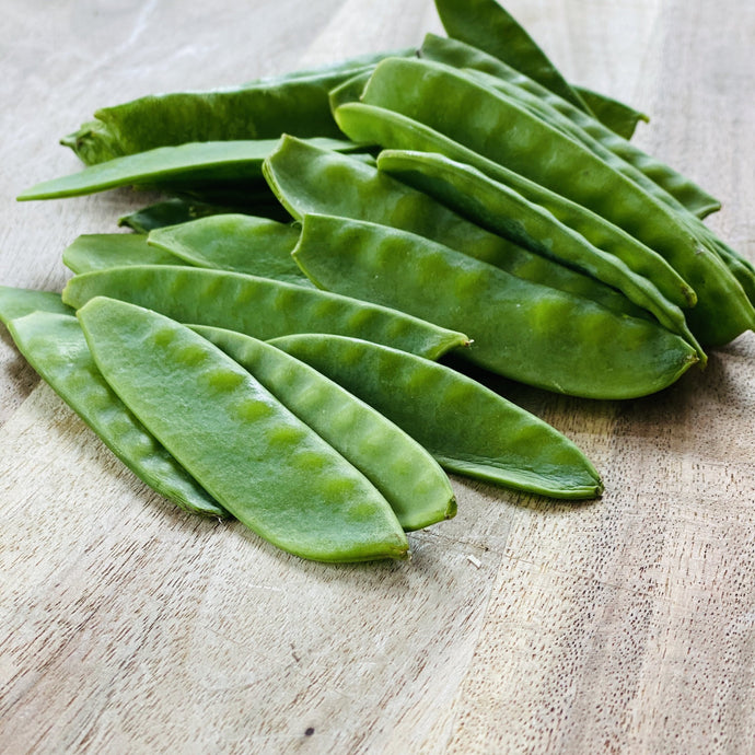 raw mange tout on a wooden board
