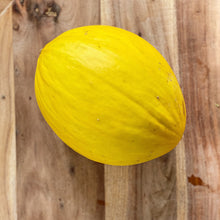 Load image into Gallery viewer, yellow whole honeydew melon on a wooden board
