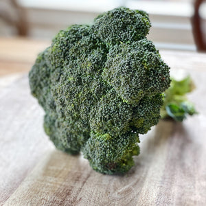crown of brocolli on a wooden board