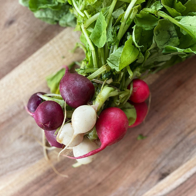 fresh Heritage radishes on a wooden board