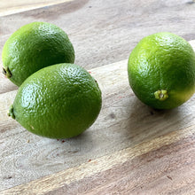 Load image into Gallery viewer, 3 fresh green limes on a wooden board
